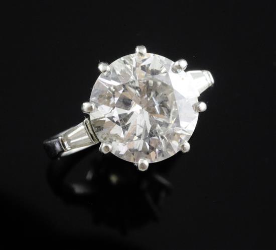 An attractive modern platinum and single stone diamond ring with trapeze cut diamond set shoulders, size K.